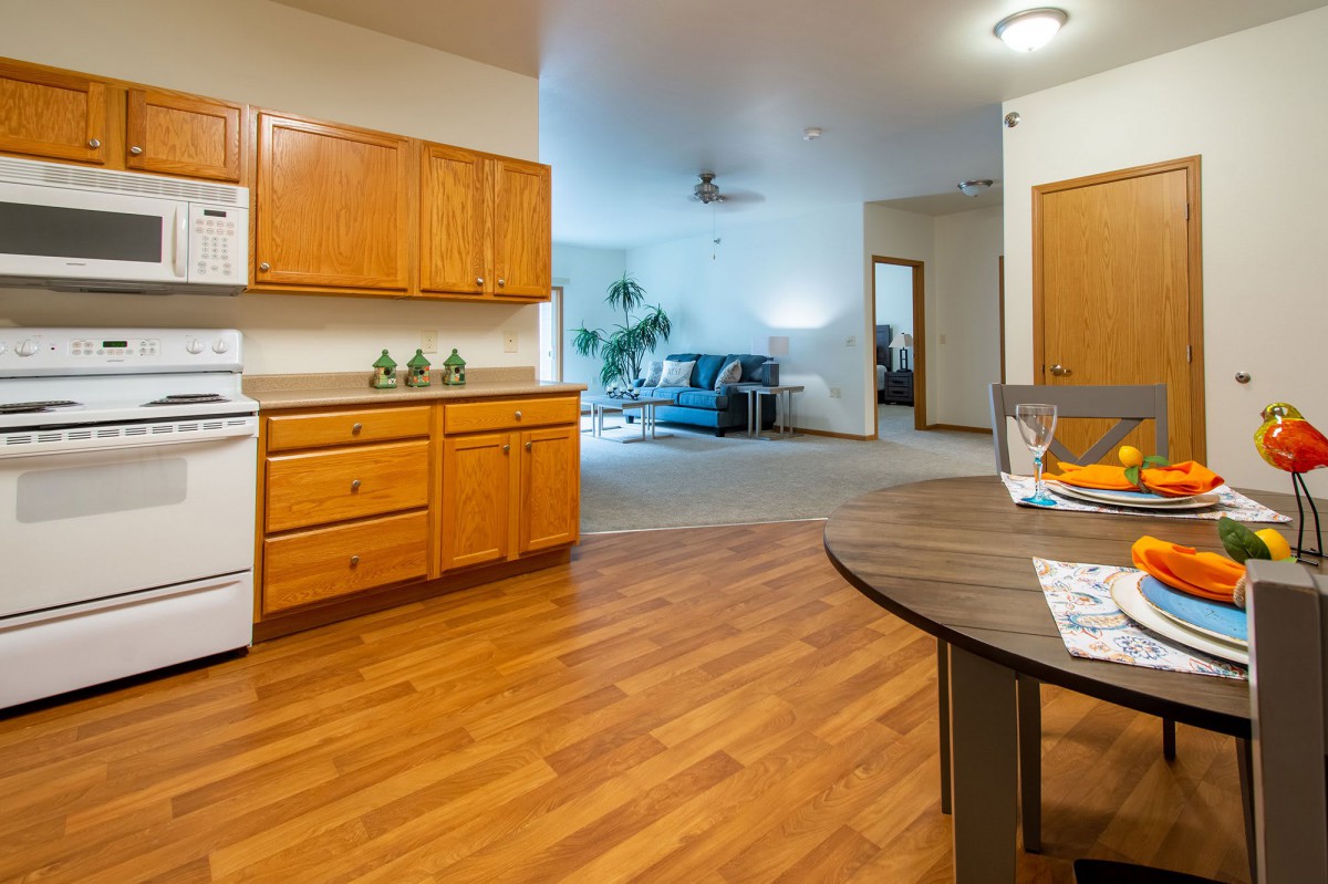 Open-concept kitchen and living room with wooden flooring.