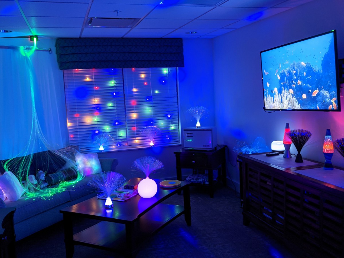 A cozy room illuminated with colorful LED lights and a TV displaying an image.