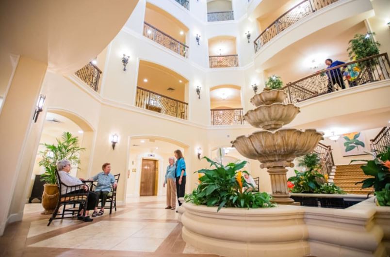 A spacious indoor atrium with a central fountain, surrounded by seating and decorative lighting.