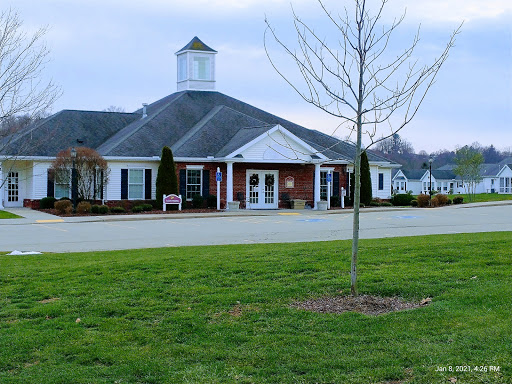 A charming community center with a classic architectural design, set against a serene landscape.
