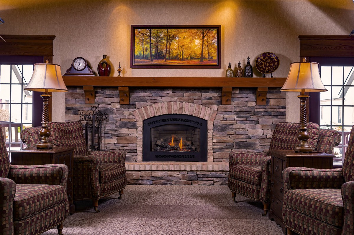A cozy living room with a stone fireplace and comfortable armchairs.