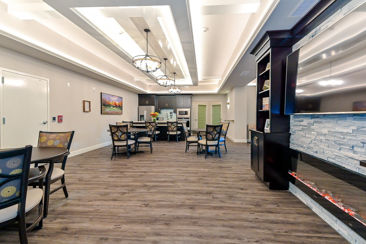 A spacious and elegantly designed dining area with chandeliers and modern furnishings.