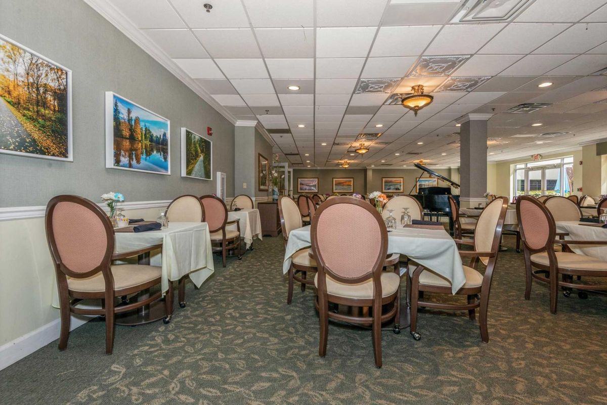 An elegantly designed dining area with tables and chairs arranged neatly under soft lighting.