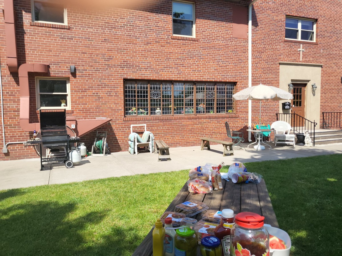 A sunny day in the backyard with a picnic setup and comfortable seating.
