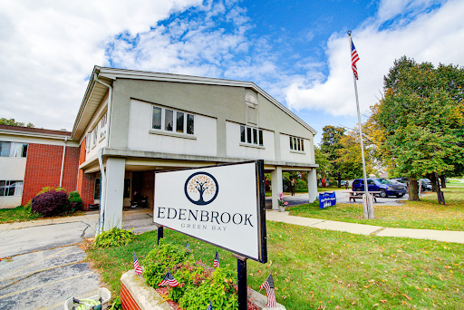 Edenbrook facility with a clear blue sky and American flag.