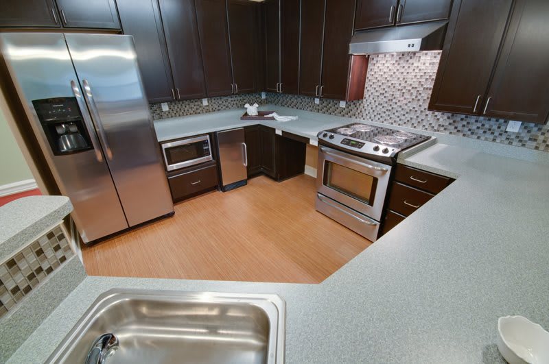 A modern kitchen featuring stainless steel appliances and wooden cabinets.