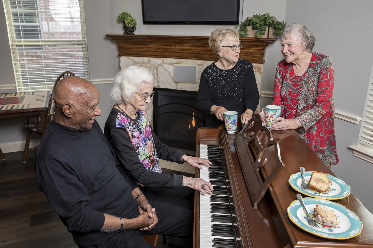 A group of seniors enjoying a music session and conversation at home.