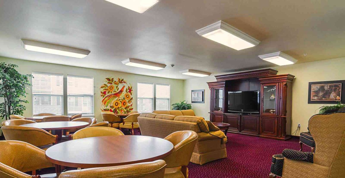 A cozy living room with comfortable seating, a television, and decorative wall art.