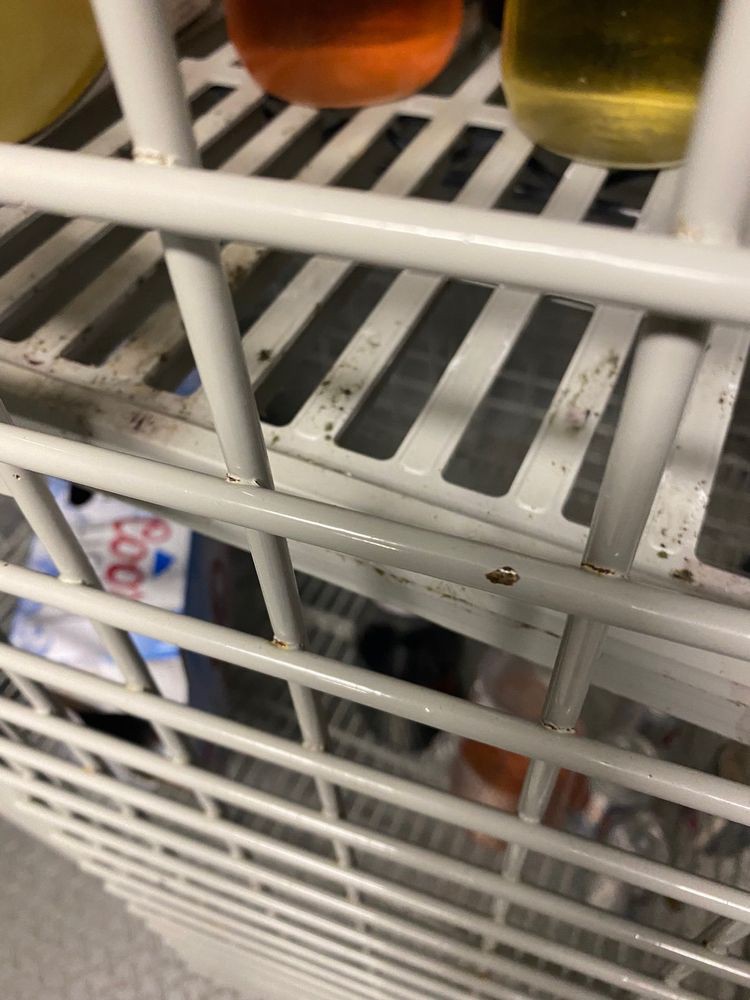 View of products on a store shelf behind metal bars.
