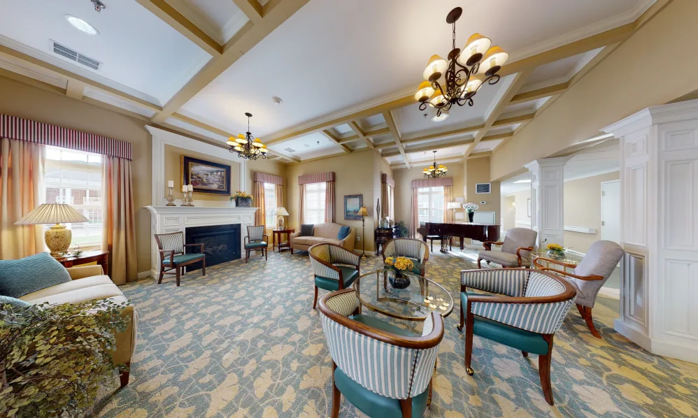 An elegant living room featuring a cozy seating area, a fireplace, and a grand piano.