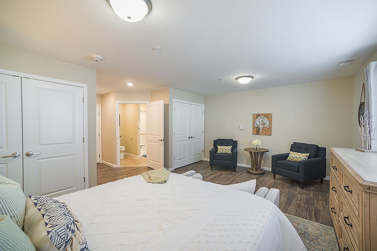 A modern bedroom interior with comfortable seating and neutral tones.