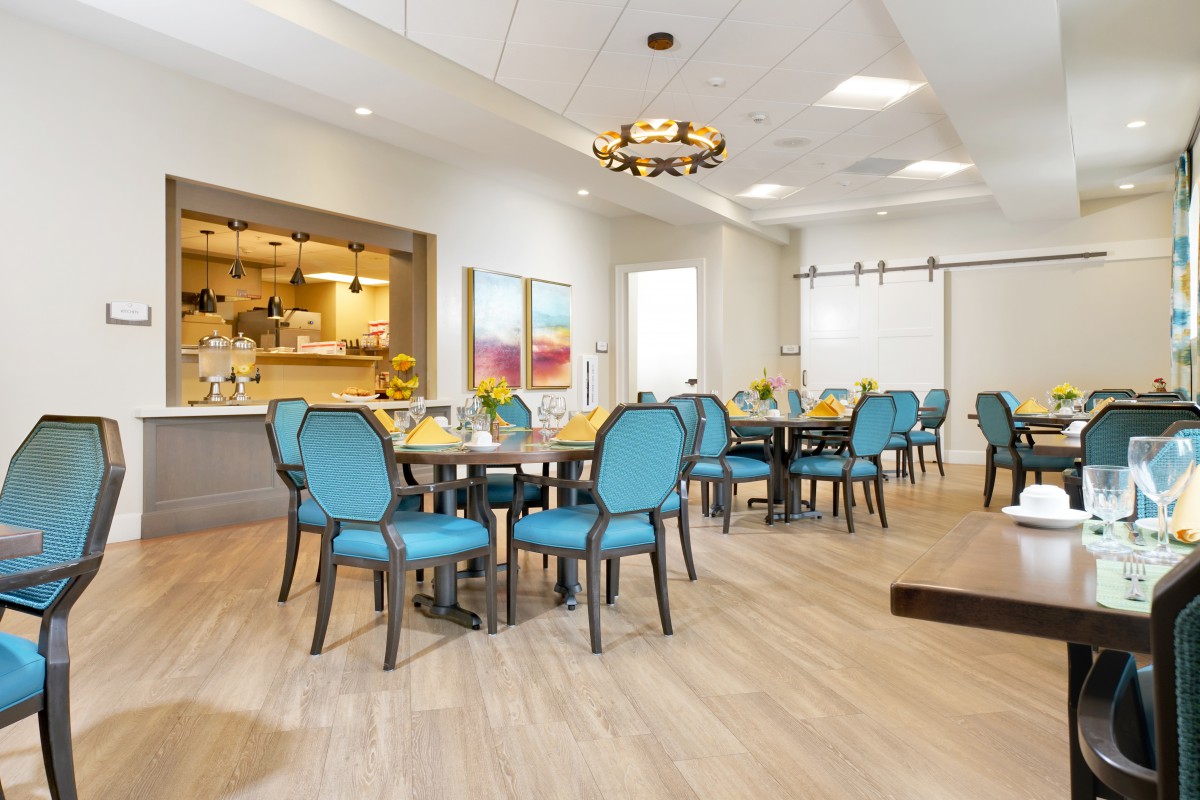 A modern dining area with blue chairs and neatly arranged tables.