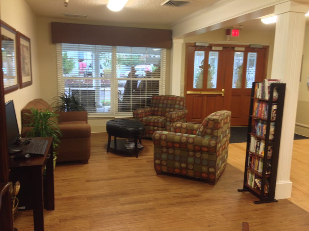 A cozy seating area in a lobby with comfortable chairs and a view through large windows.