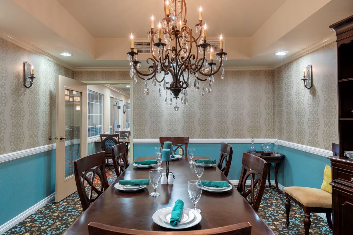 An elegant dining room with a chandelier and a sophisticated table setting.
