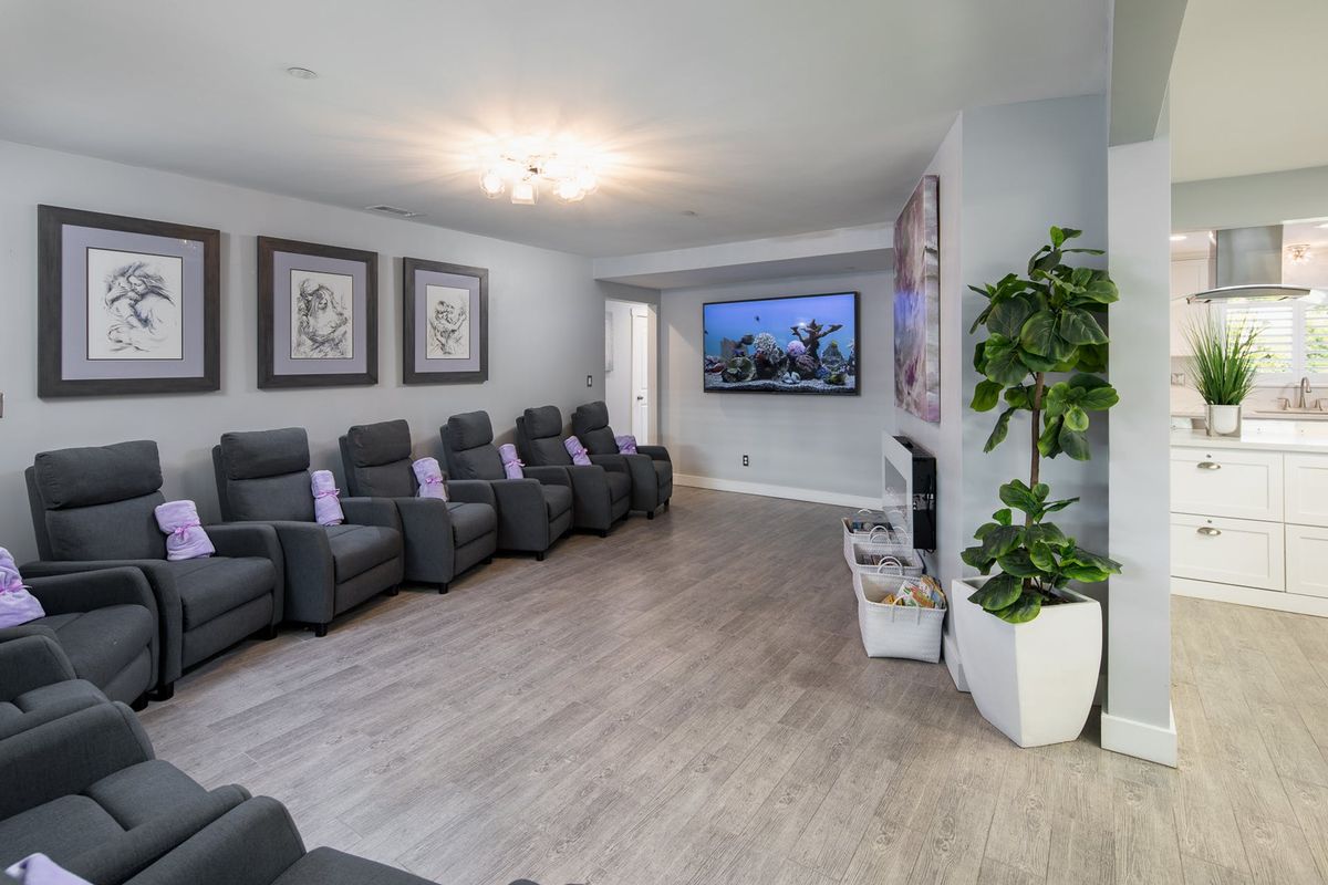 A modern home theater room with comfortable seating and a large screen TV.