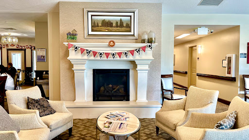 A cozy living room featuring a stylish fireplace adorned with decorative banners and comfortable seating.
