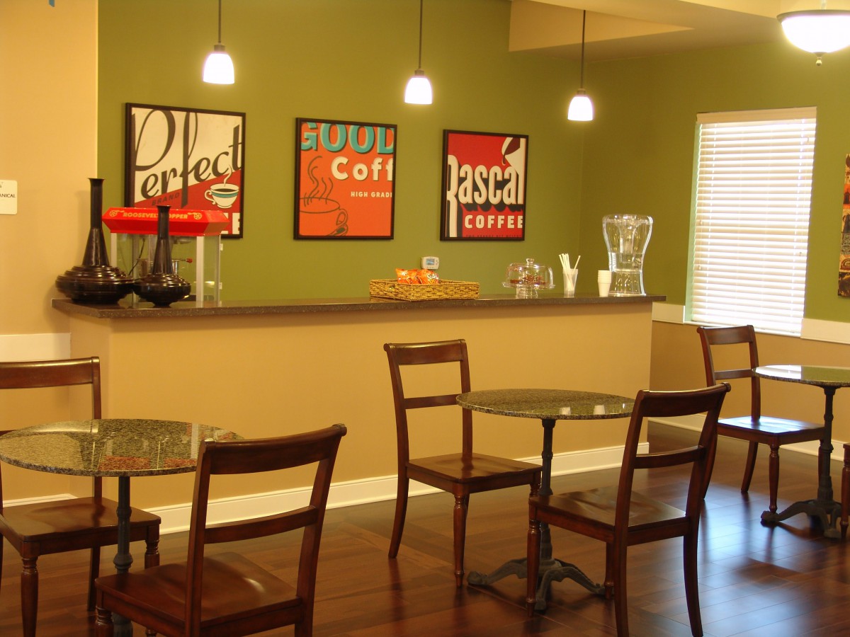 A modern cafe interior with tables, chairs, and contemporary artwork on the walls.