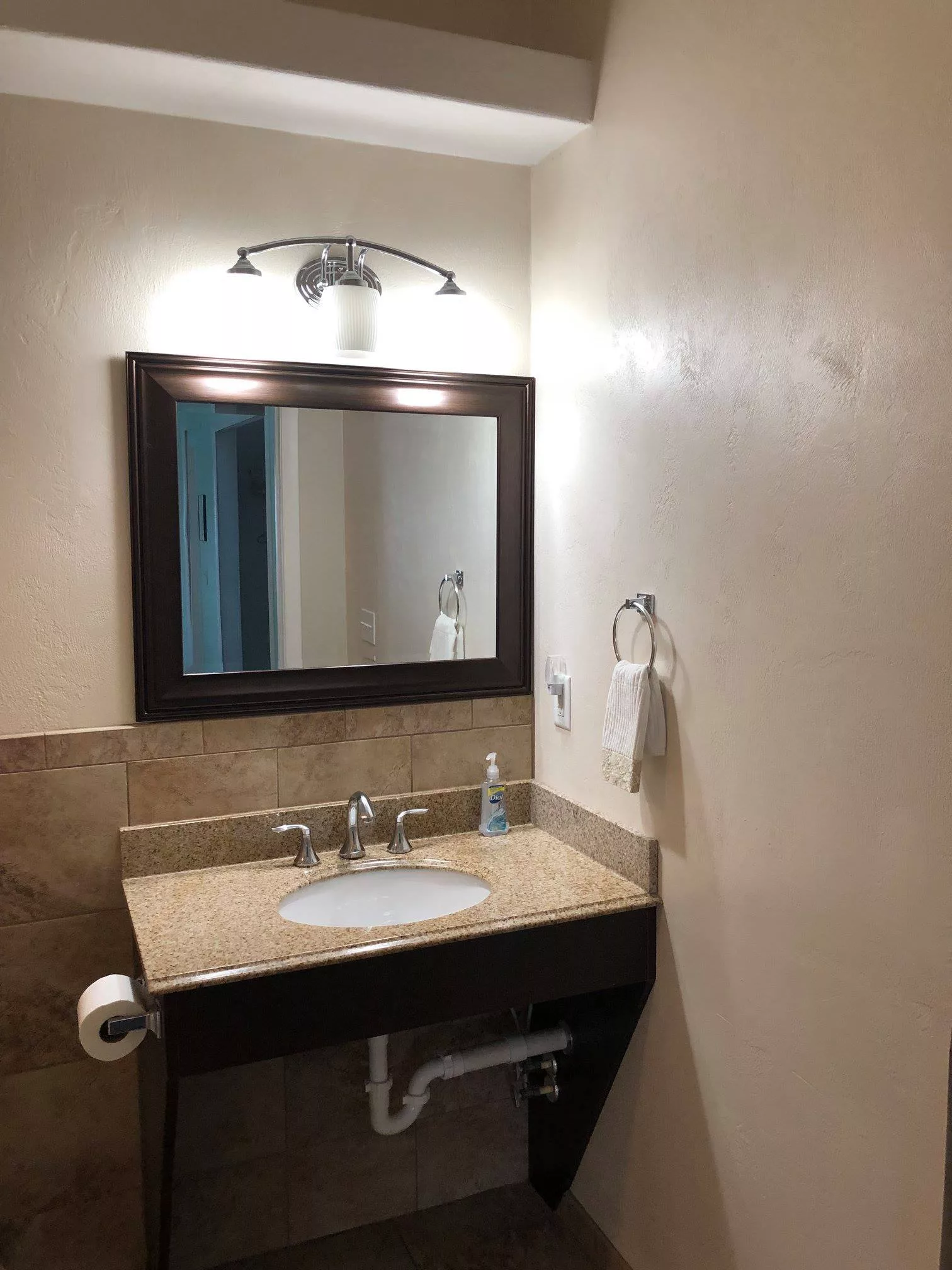 A modern bathroom with a sink, mirror, and wall-mounted towel rack.