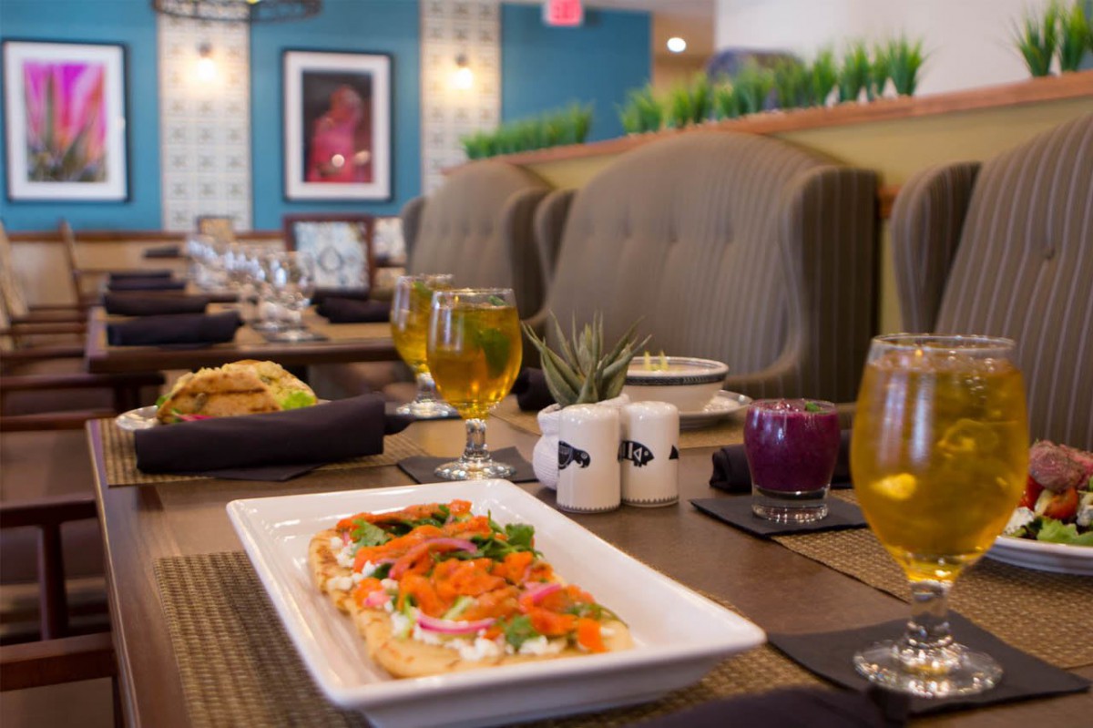 A beautifully set table in a cozy restaurant featuring an appetizing dish and refreshing drinks.