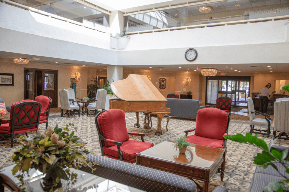 A spacious hotel lobby featuring a grand piano and comfortable seating arrangements.