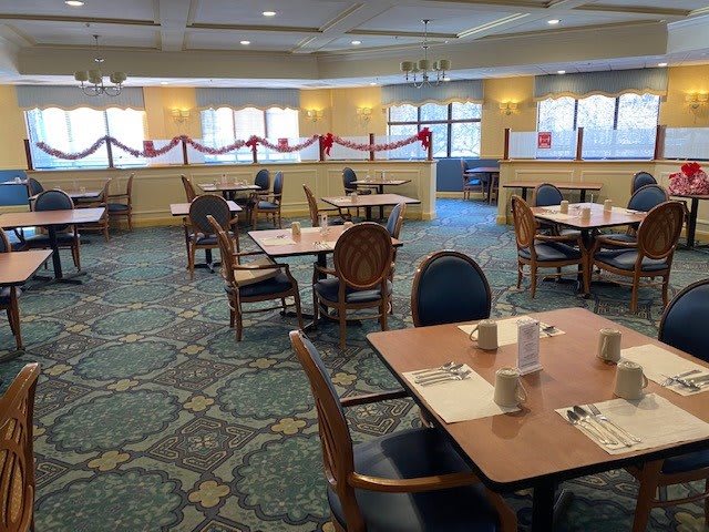 An empty dining area with neatly arranged tables and chairs, featuring decorative elements.