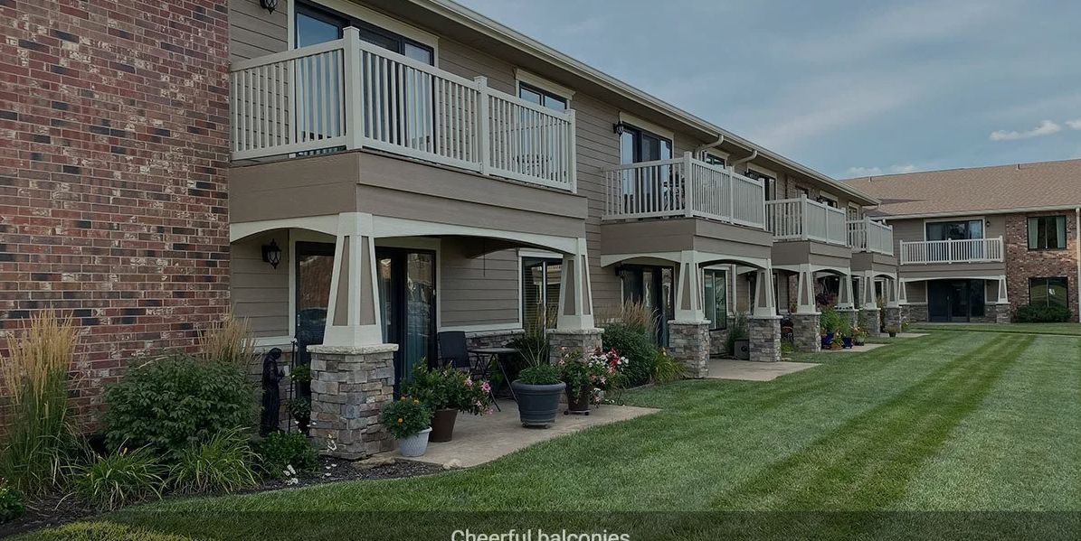 Modern apartment complex with balconies and landscaped surroundings.