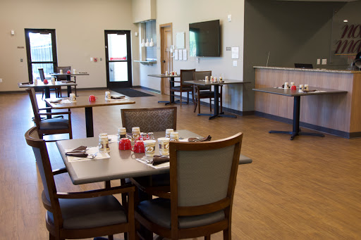 A spacious and modern dining area with neatly arranged tables and chairs, ready for guests.