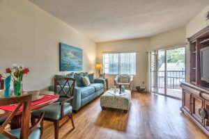 A cozy and brightly lit living room with comfortable seating and wooden flooring.