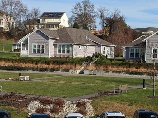 A picturesque residential house surrounded by well-maintained landscaping and open green space.