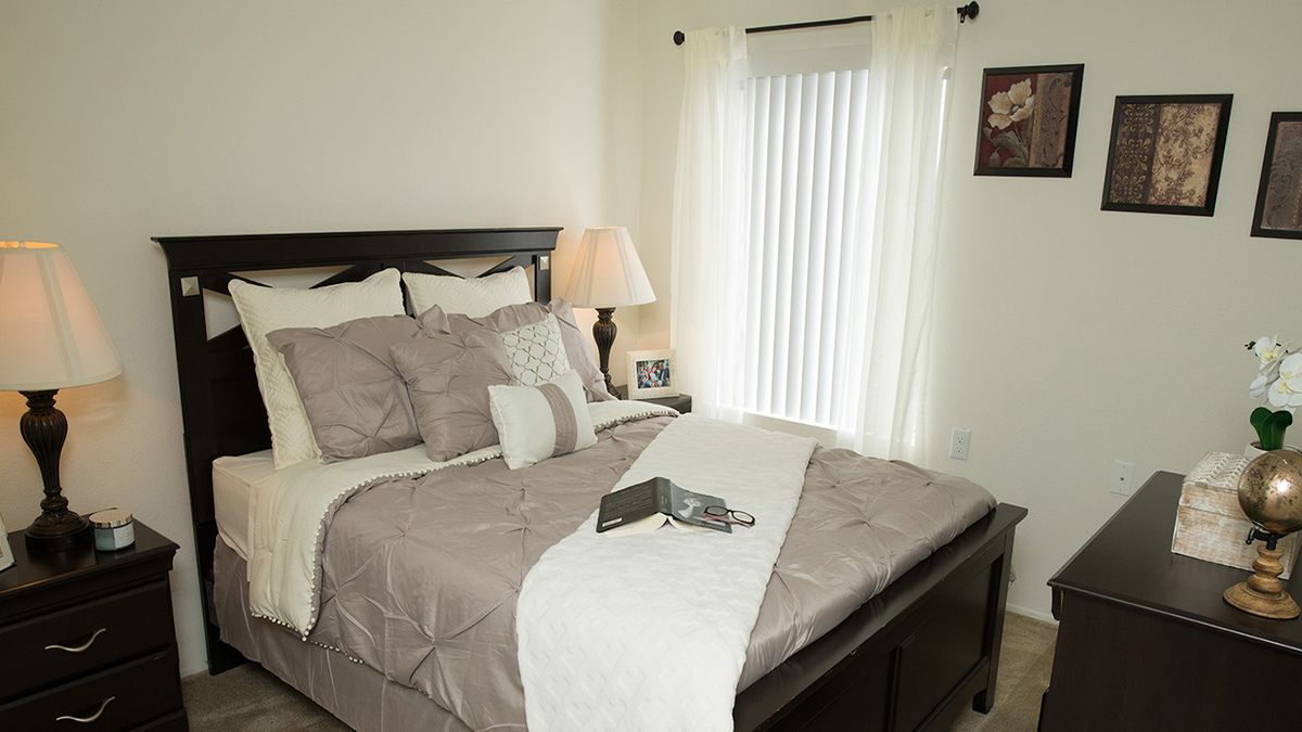 A cozy bedroom with a neatly made bed and soft lighting.