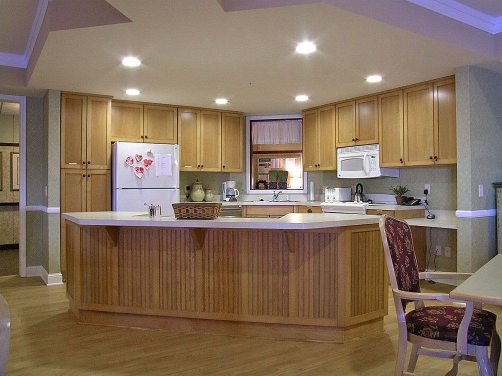 A cozy kitchen featuring wood cabinets and a central island counter with modern lighting.
