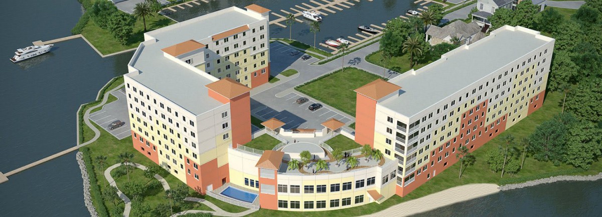 An aerial view of a modern apartment complex with a landscaped courtyard and nearby marina.