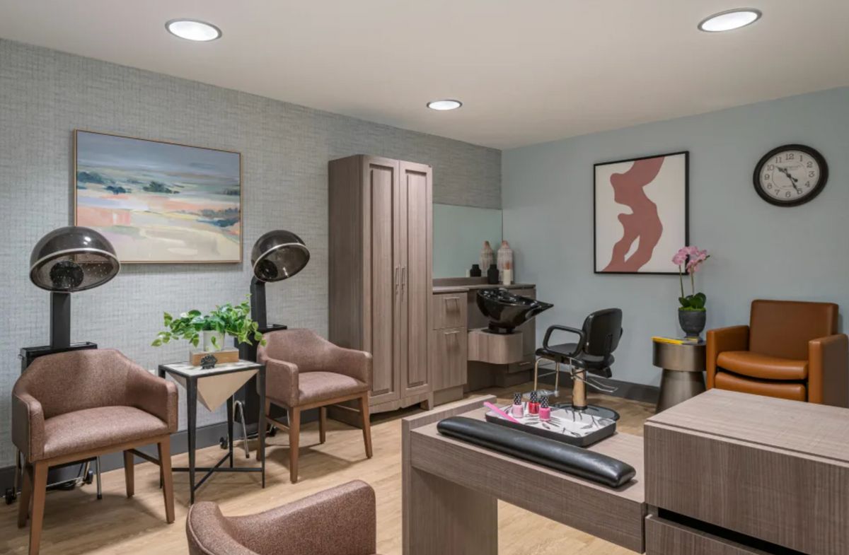 A modern hair salon interior featuring stylish furniture and decorative artwork.