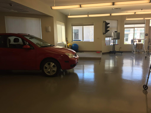 A red car parked inside a spacious garage with ample natural light.