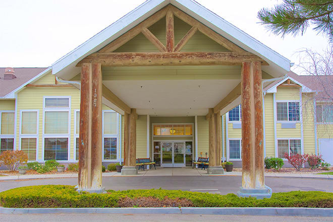 A building entrance with large wooden columns and a covered entryway.