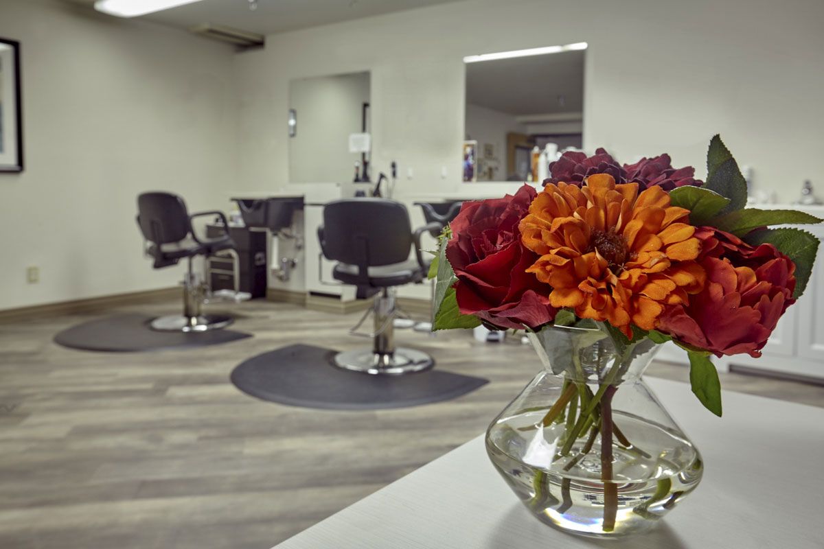 A modern hair salon interior with styling chairs and vibrant flowers.