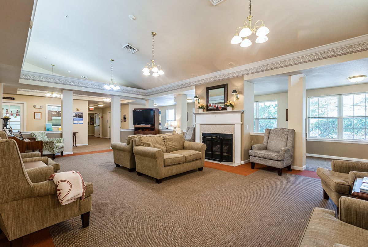 A spacious and well-decorated living room with comfortable seating, a fireplace, and a large TV.