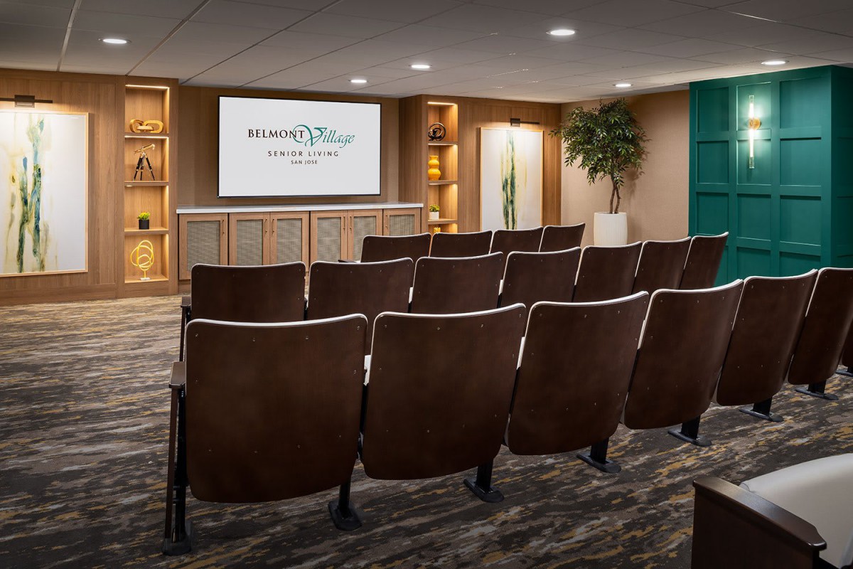 A modern conference room with rows of seating and a presentation screen.