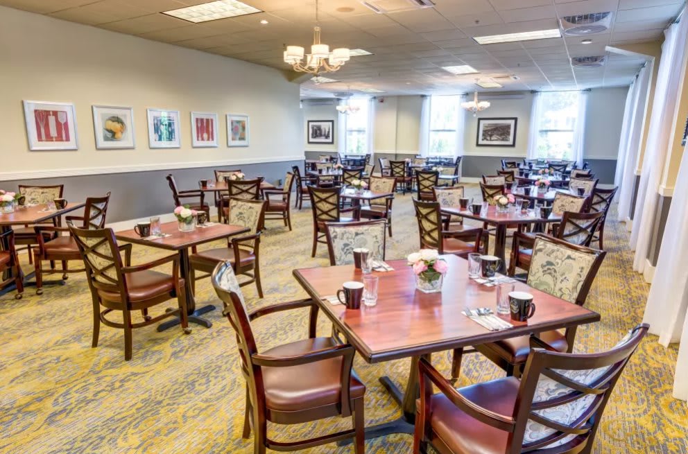 An empty dining room with neatly arranged tables and chairs.