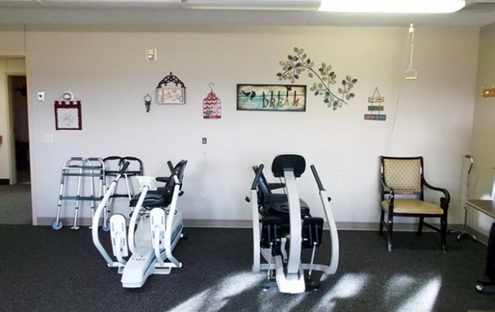 A gym interior featuring stationary bikes and decorative wall art.
