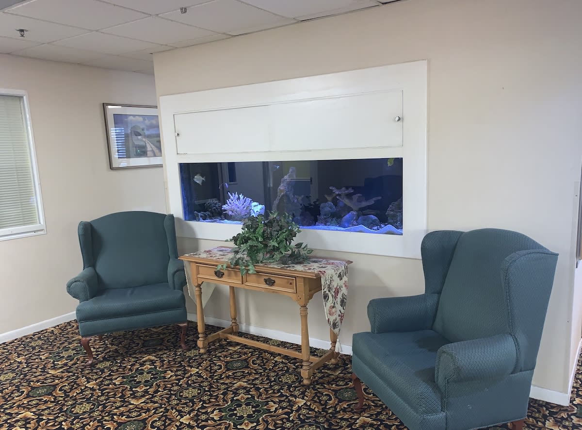 A cozy waiting room with an aquarium and comfortable seating.