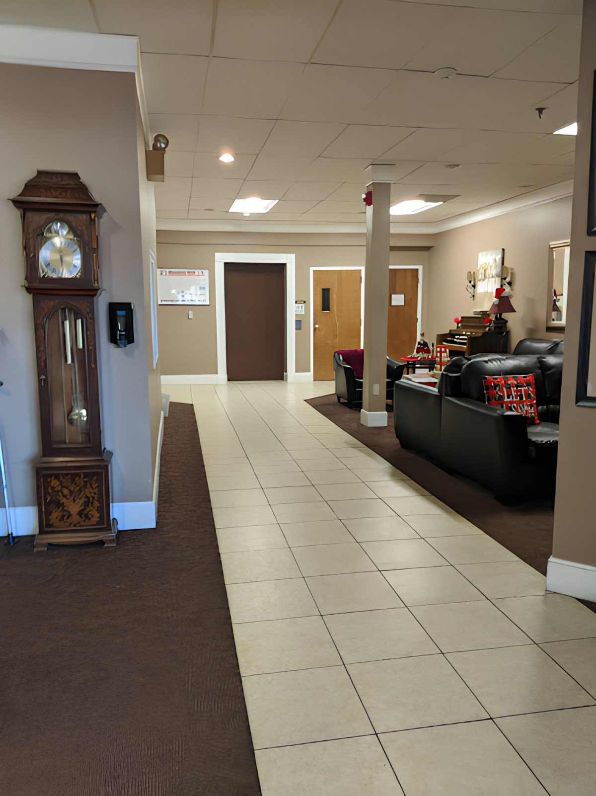 A spacious lobby area with a grandfather clock and seating arrangement.