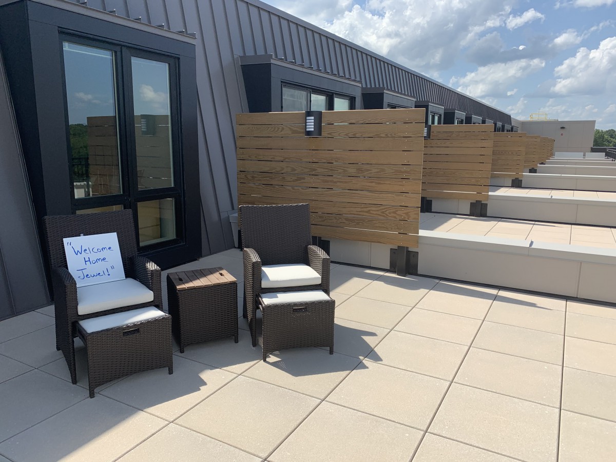 A modern rooftop patio with outdoor furniture and a clear sky.