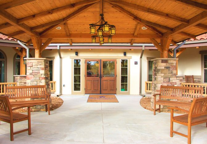 A welcoming building entrance with wooden accents and seating.