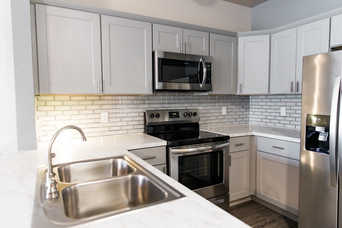 A modern kitchen with stainless steel appliances and white cabinetry.