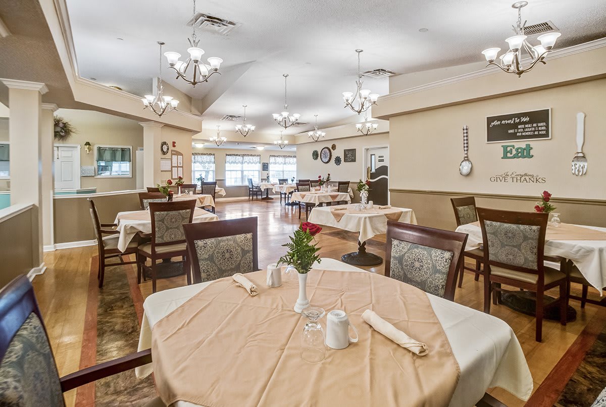 An elegant dining area with neatly arranged tables and chandeliers.