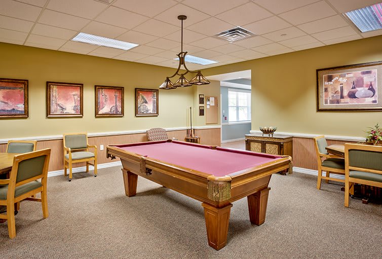 A cozy game room featuring a pool table with pink felt and stylish lighting.