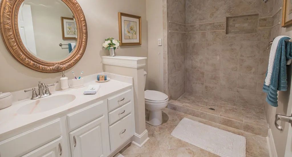 A modern bathroom featuring a sink, toilet, and spacious shower area.