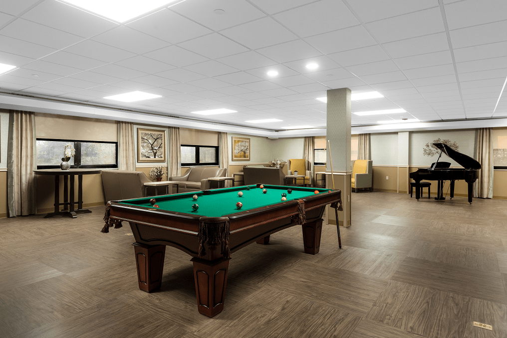 A spacious game room featuring a pool table, comfortable seating, and stylish decor.