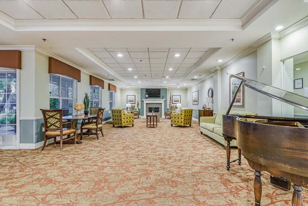 A spacious and elegantly designed lounge area with comfortable seating, a fireplace, and large windows.